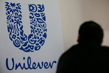 A person stands in front of the Unilever logo. Reuters