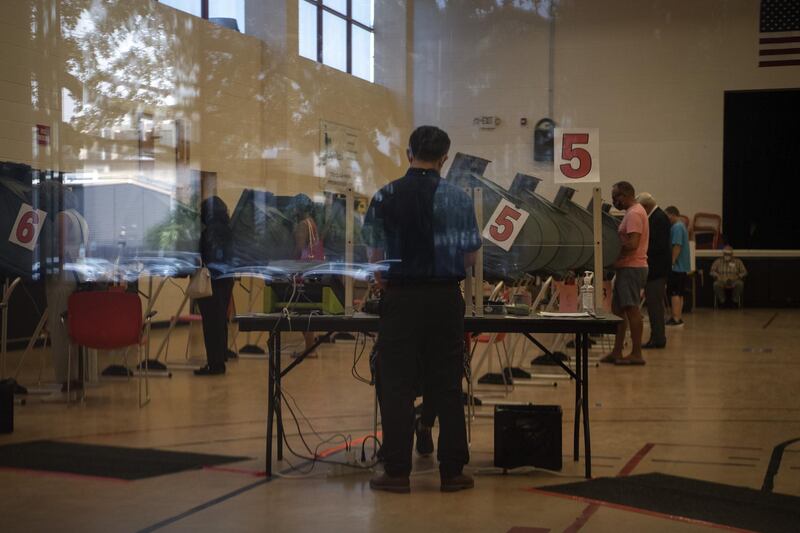 A voter prepares to cast a ballot at an early voting polling location for the 2020 Presidential elections in Houston, Texas, U.S. Texas restrictions allowing only a single drop-box for mail-in ballots in each county were reinstated by a federal appeals court that said the governor's concerns about ballot security outweigh voting-rights activists' worries that millions of voters won't be able to safely access the drop-box. Bloomberg