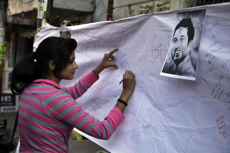 An India fan signs a banner commemorating Sachin. Channi Anand / AP