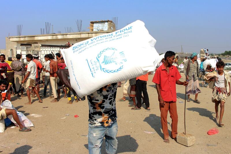 Displaced Yemenis receive humanitarian aid, donated by the World Food Programme (WFP) in cooperation with the Danish Refugee Counci ( DRC), in the northern province of Hajjah on December 30, 2019. - Tens of thousands of people, most of them civilians, have been killed since Saudi Arabia and its allies intervened in March 2015 in support of the beleaguered government. The fighting has also displaced millions and left 24.1 million -- more than two-thirds of the population -- in need of aid. (Photo by ESSA AHMED / AFP)