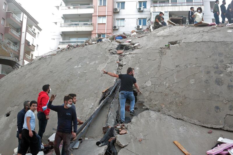 Rescue workers and people search for survivors at a collapsed building after a 7.0 magnitude earthquake in the Aegean Sea in Izmir, Turkey.  EPA
