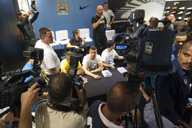 Matija Nastasic (obscured), left, Stevan Jovetic, centre and Samir Nasri, right, during their autograph signing at Marina Mall in Abu Dhabi on Tuesday. Mona Al-Marzooqi / The National / May 13, 2014