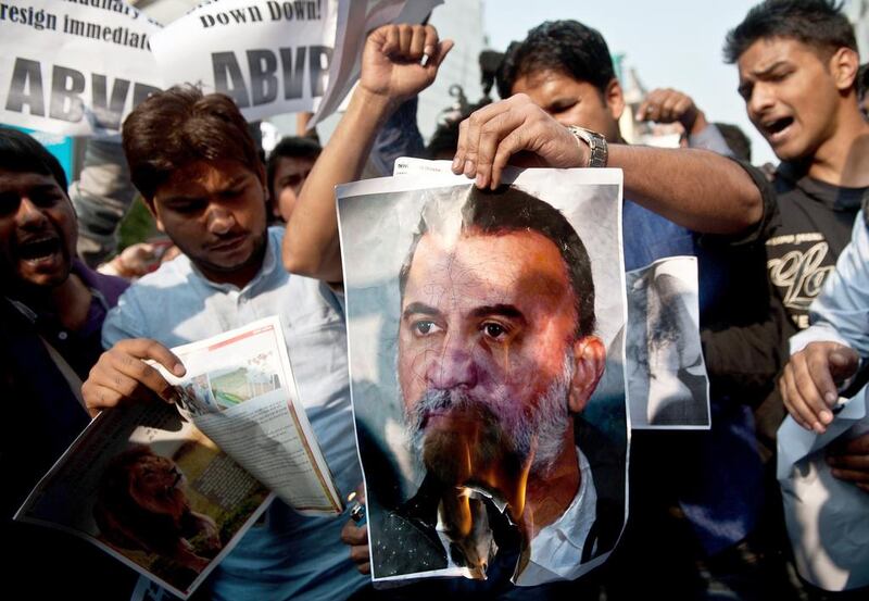 Activists of Akhil Bharatiya Vidya Parishad (ABVP) burn a photograph of Tarun Tejpal, founder and editor of Tehelka magazine, outside the magazine's office in New Delhi on November 22, 2013. The editor of India's leading investigative news magazine was accused of trivialising a serious sex crime after he announced he would take six months' leave as "penance" for assaulting a female colleague.  AFP PHOTO/MANAN VATSYAYANA