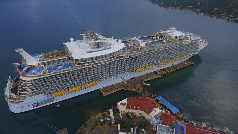 Handout aerial picture released by Honduras Presidency showing the the largest passenger ship in the world by gross tonnage, the cruise MS Symphony of the Seas, docked in Roatan, Islas de la Bahia, in Honduras' Caribbean, on November 19, 2018. (Photo by HO / Honduras' Presidency / AFP) / RESTRICTED TO EDITORIAL USE - MANDATORY CREDIT "AFP PHOTO / HONDURAS PRESIDENCY" - NO MARKETING NO ADVERTISING CAMPAIGNS - DISTRIBUTED AS A SERVICE TO CLIENTS