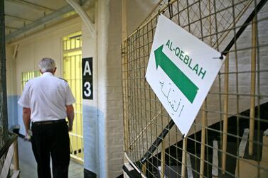 A prison guard walks past a sign to the prison mosque inside Wandsworth prison. Getty Images
