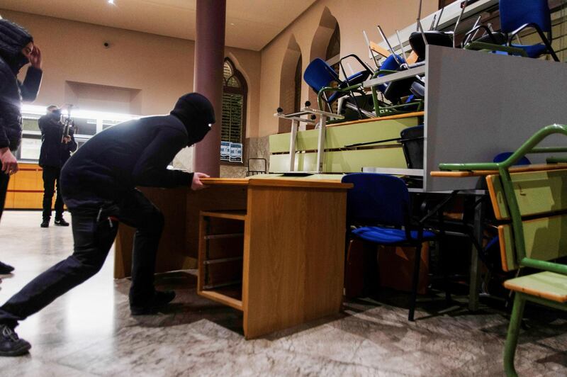 Demonstrators push tables to strengthen their barricades. Reuters