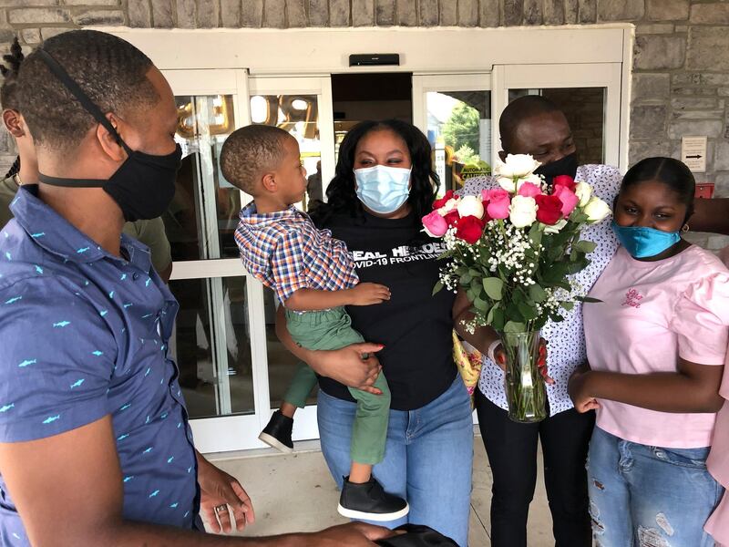 Teisha Roberts, center, a nursing director, is greeted by her family as she prepares to leave Park Springs elder care facility in Stone Mountain, Georgia. Workers who agreed to live at Park Springs to keep its residents safe from the coronavirus are back with their loved ones for the first time in nearly three months. AP Photo