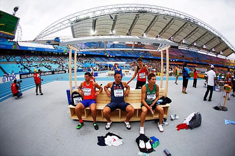 Decathletes relax during the discus event of their 10-event competition. 

DIEGO AZUBEL / EPA