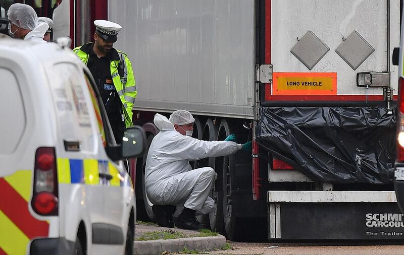 (FILES) In this file photo taken on October 23, 2019 British Police forensics officers work on lorry, found to be containing 39 dead bodies, at Waterglade Industrial Park in Grays, east of London, on October 23, 2019. Two key defendants accused of manslaughter and people smuggling after 39 Vietnamese migrants were found dead in the back of a lorry were found guilty by a London court on December 21, 2020. At the conclusion of the 10-week trial, Romanian Gheorghe Nica, 43, and Eamonn Harrison, 24, were found guilty on Monday of 39 counts of manslaughter. The pair, are expected to be sentenced early in January.
 / AFP / Ben STANSALL
