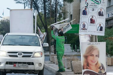 Jordanian municipal workers remove campaign posters a day after parliamentary elections in the capital Amman. AFP