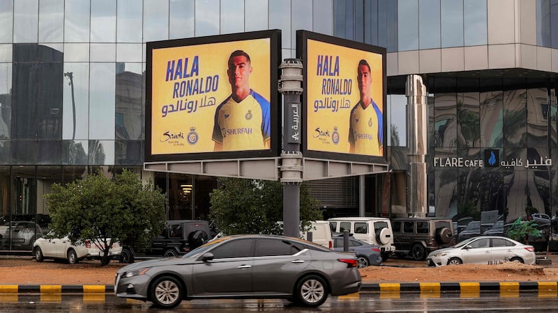 A vehicle drives past a billboard welcoming Saudi football club Al Nassr's new signing - Portuguese star Cristiano Ronaldo - in Riyadh. AFP