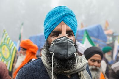 A farmer wears a mask to protect himself from tear gas fired by the police at the Shambhu border. Reuters