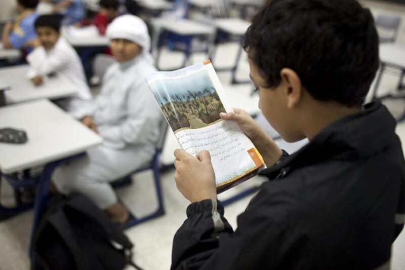 Al Ruwais Primary Boys School students read during an Arabic language class at the school's campus in Ruwais. Silvia Razgova / The National

