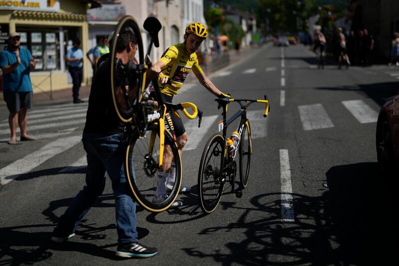 Overall race leader Jonas Vingegaard changes bikes after crashing during the stage. AP