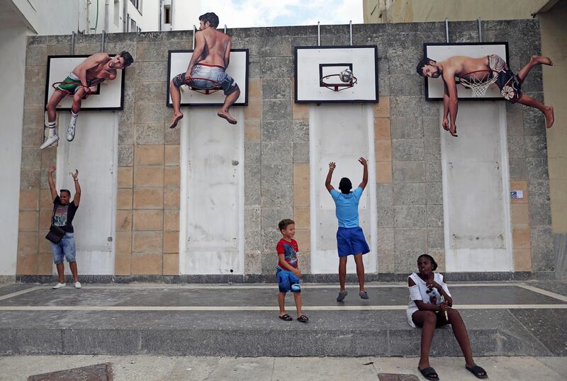 Children play basketball with an installation by Spanish artists Martin and Sicilia. REUTERS