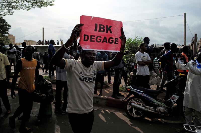 A protester holds a sign during a protest reading "Ibrahim Boubacar Keita get out". Reuters