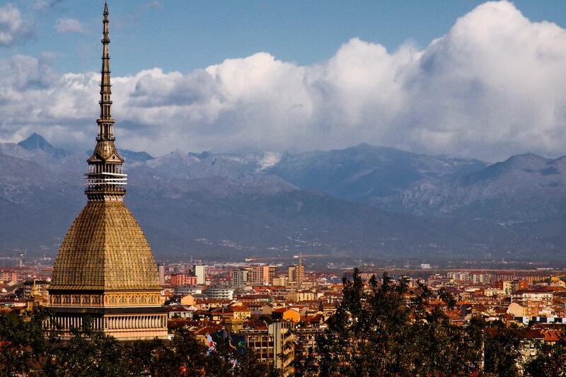 The 167-metre-tall Mole Antonelliana, which is home to the National Museum of Cinema, towers above the rooftops of the Italian city of Turin. The Alps are visible in the background. Getty Images