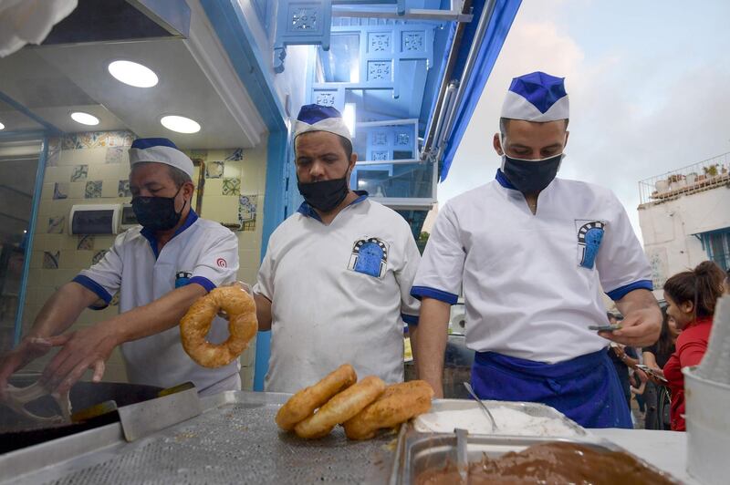 Tunisian cooks prepare a local version of the doughnut, known as Bambalouni, in the village of Sidi Bou Said, northeast of Tunis.   AFP