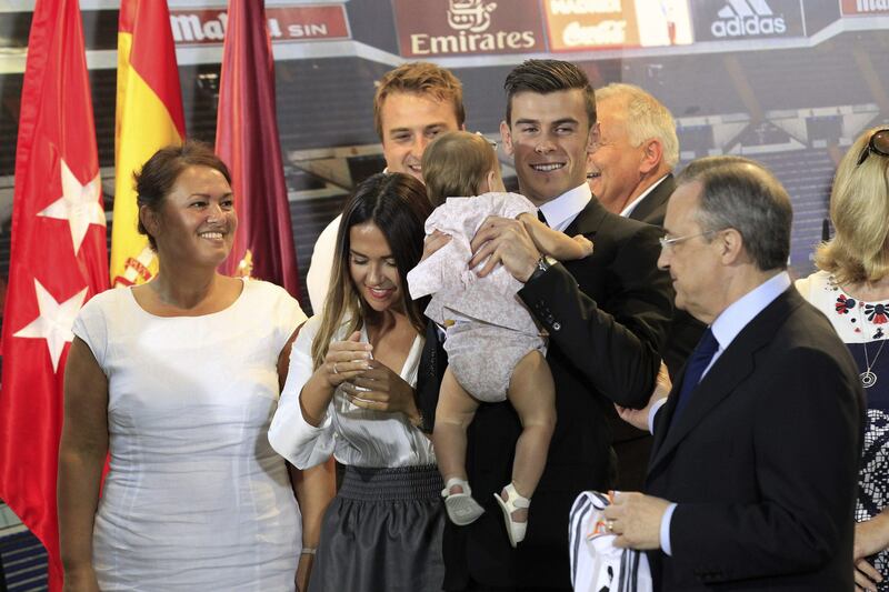 epa03847761 Welsh midfielder Gareth Bale (C) poses surrounded by members of his family and Real Madrid's President, Florentino Perez (R), during his presentation as new player of Real Madrid at Santiago Bernabeu stadium in Madrid, Spain, 02 September 2013.  EPA/ZIPI *** Local Caption ***  03847761.jpg