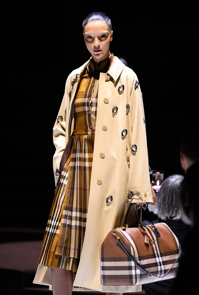 Burberry's iconic trench coat was augmented with chains, worn as a dress or printed with trompe l'oeil images.
