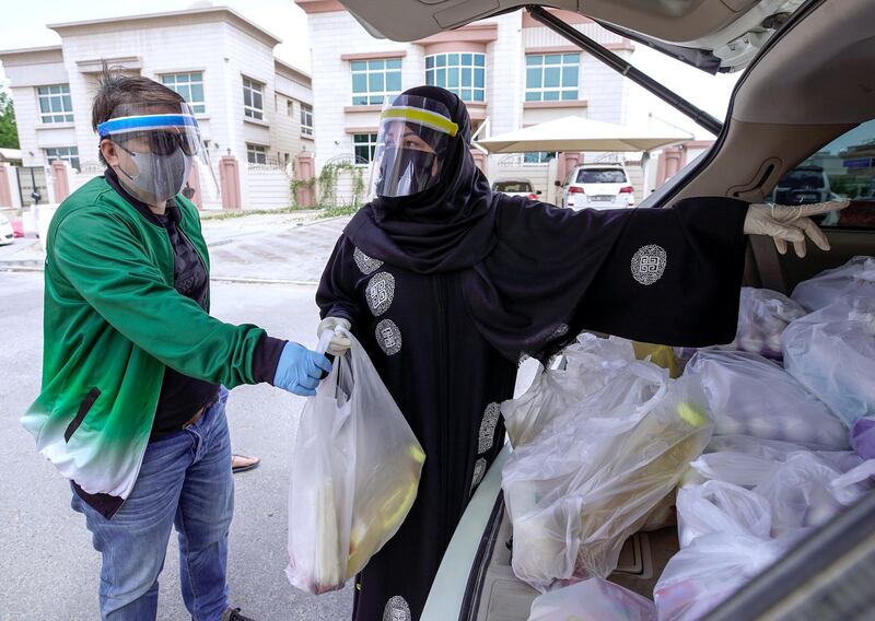 Abu Dhabi, United Arab Emirates, May 1, 2020.   
 Filipino-Emirati citizen, Mona Mohamed Baraguir  (right) donates rice, eggs, cooking oil and other daily essentials to laid off workers at the Khalifa A neighborhood on a Friday morning.
Victor Besa / The National
Section:  NA
Reporter:  Shireena Al Nuwais