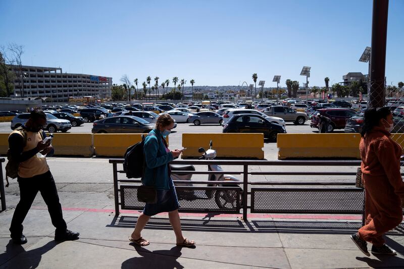 People and cars wait to cross the border at San Ysidro, California. Reuters
