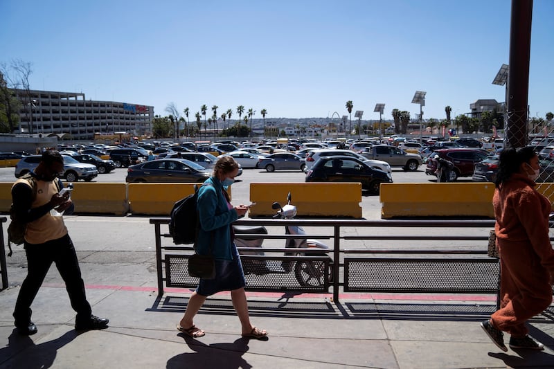 People and cars wait to cross the border at San Ysidro, California. Reuters