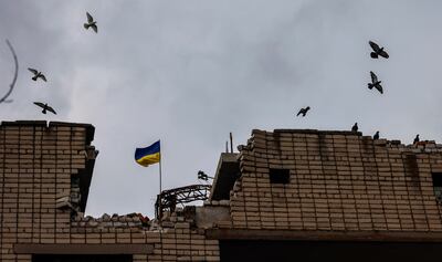 The Ukrainian national flag is raised over the destroyed vocational school building in Arkhanhelske, in the northern Kherson region. EPA 