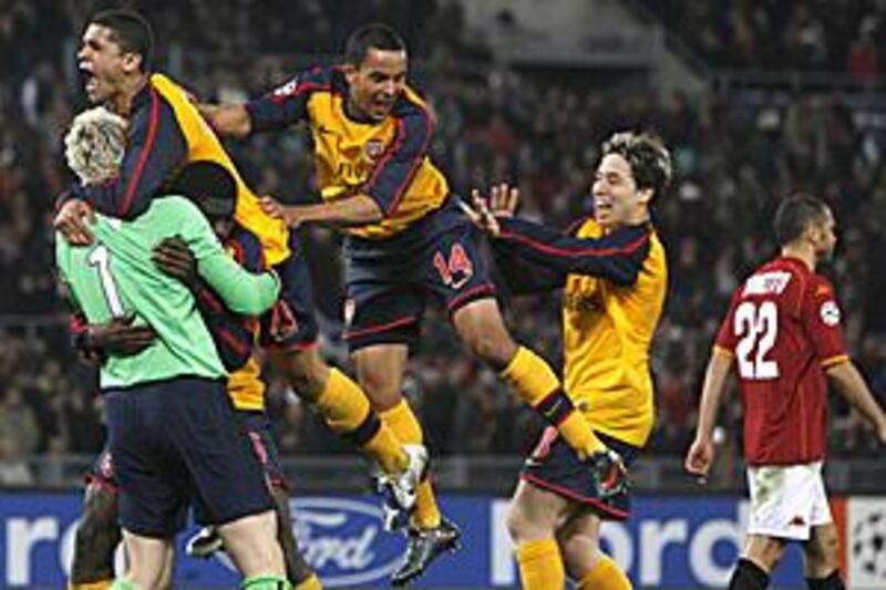 The Arsenal goalkeeper Manuel Almunia, left, is mobbed by teammates after helping his side win the shoot-out.
