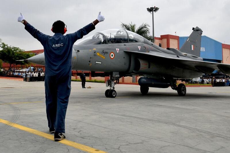 A marshal guides the Tejas light combat aircraft carrying Indian Defence Minister Rajnath Singh preparing to take off on a sortie at HAL Airport in Bangalore. All photos: AFP