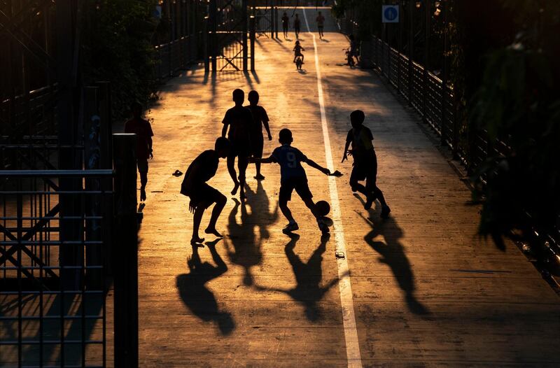 Children play football in Bangkok, Thailand as a state of emergency begins. AP Photo