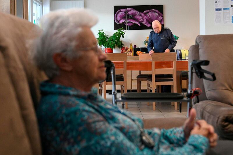 Jean, a resident sets the table in the common room on November 20, 2018, at the Ages et Vie retirement home in Besancon, eastern France. The Ages et Vie retirement home is an atypical home shared by seven eldery residents who live in a family-like atmosphere. Every resident has their own room, bathroom and a private access to the garden. Meals are served in a bright common room. Two out of seven caregivers live in the home as well in order to keep the residents compagny when needed. Ages et Vie counts 54 establishments in France. / AFP / SEBASTIEN BOZON
