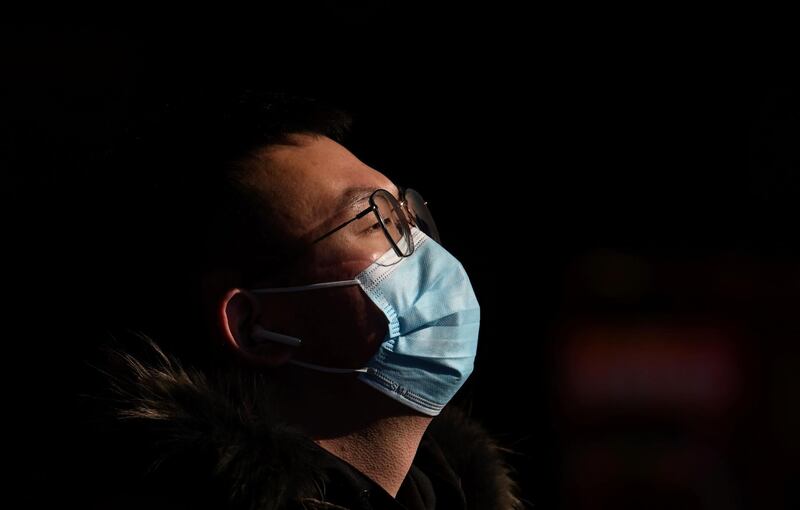 A passenger wearing a protective face mask arrives at Beijing railway station in China. AFP