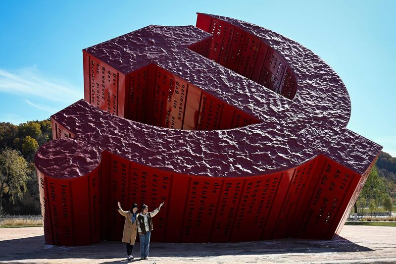 People pose for photos next to a Communist monument in Nanniwan in Yan’an city in the north-west Shaanxi province.  AFP