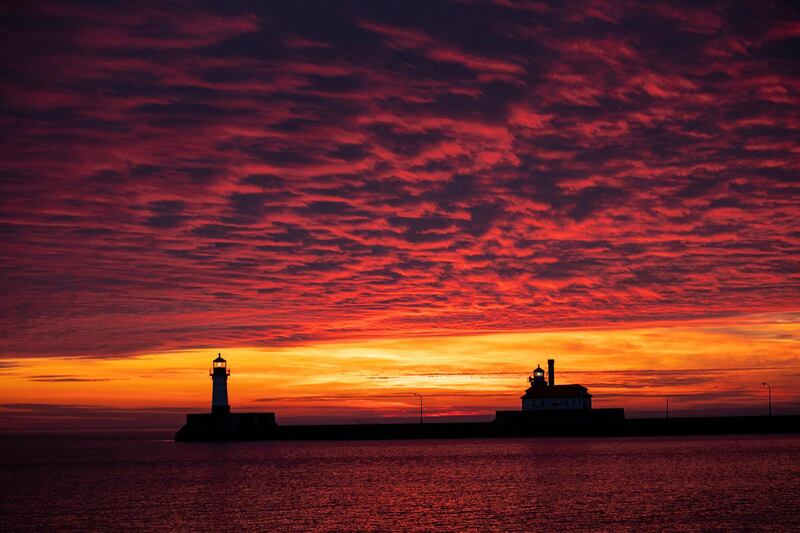 The first sunrise of 2020 brings deep orange and pink colors over the Duluth Harbor North and South Breakwater Lighthouses in the US. AP