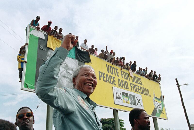 African National Congress (ANC) President Nelson Mandela greets young supporters who wait for atop a billboard in a township outside Durban, 16 April 1994 prior to an election rally. South Africans will vote 27 April 1994 in the country's first democratic and multiracial general elections.