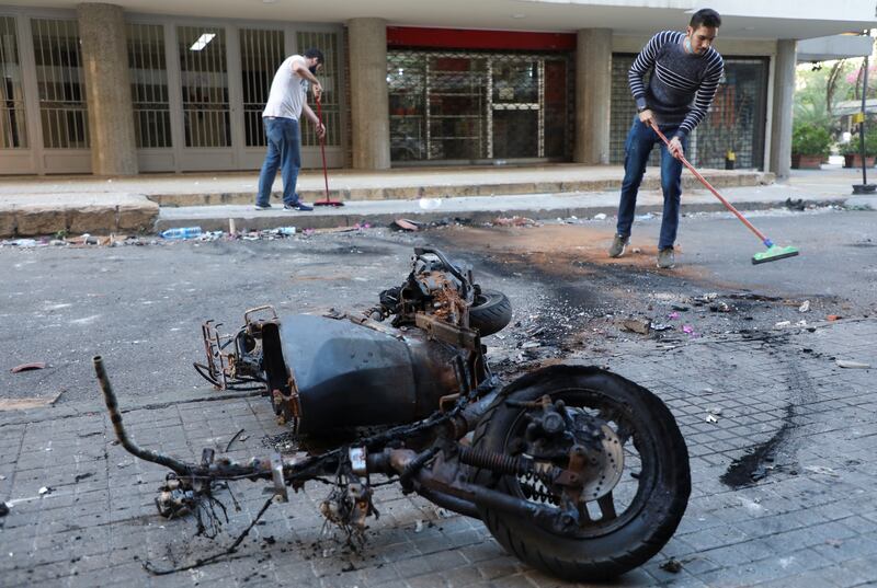 People clean up a street a day after clashes and gunfire erupted in Beirut, Lebanon. Reuters