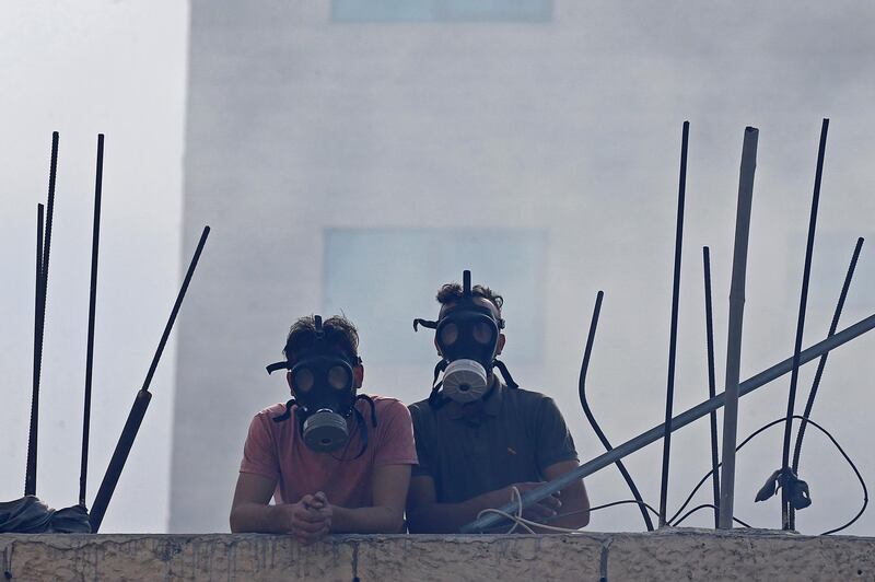 Palestinian demonstrators wearing masks watch anti-Israel protest in Bethlehem, in the occupied West Bank. Reuters
