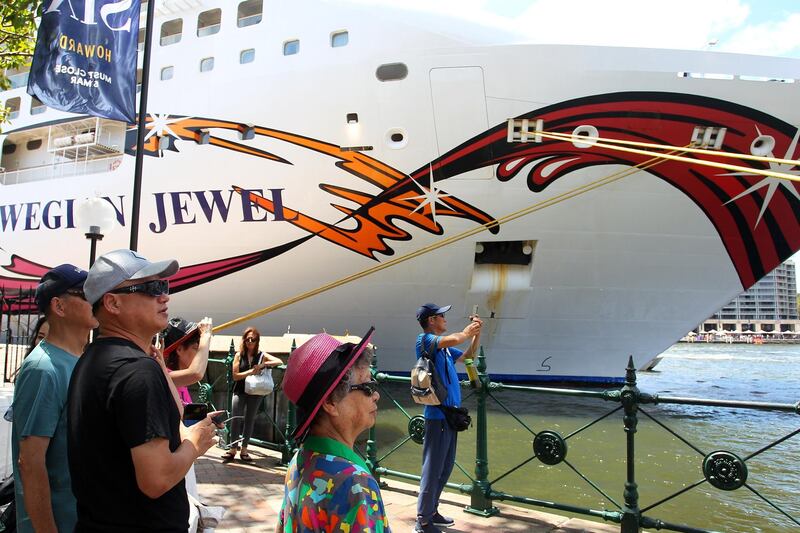 Tourists take photos at the Overseas Passenger Terminal as the Norwegian Jewel cruise ship is in lock-down while health authorities test a man for Coronavirus  in Sydney, Australia. Getty Images