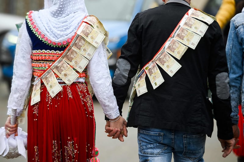 Eminkova and Kiselov. Guests traditionally pin money on the bride and groom when they marry. AFP