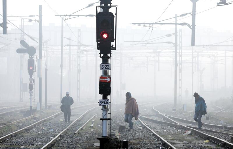 People cross railway tracks during a cold and foggy morning in Amritsar, India.  The region witnessed dense morning fog as the winter season approaches.  EPA