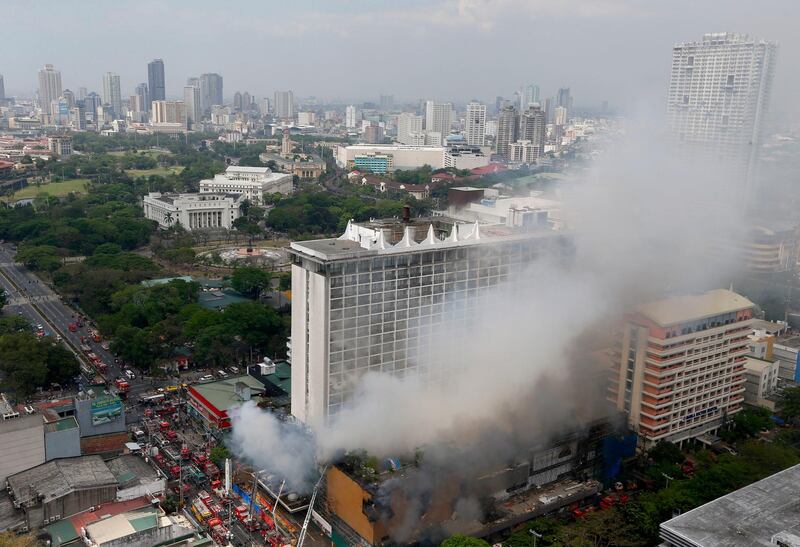 Firemen battle a fire that engulfs the Manila Pavilion Hotel and Casino Sunday, on March 18, 2018 in Manila, Philippines. Bullit Marquez / AP Photo