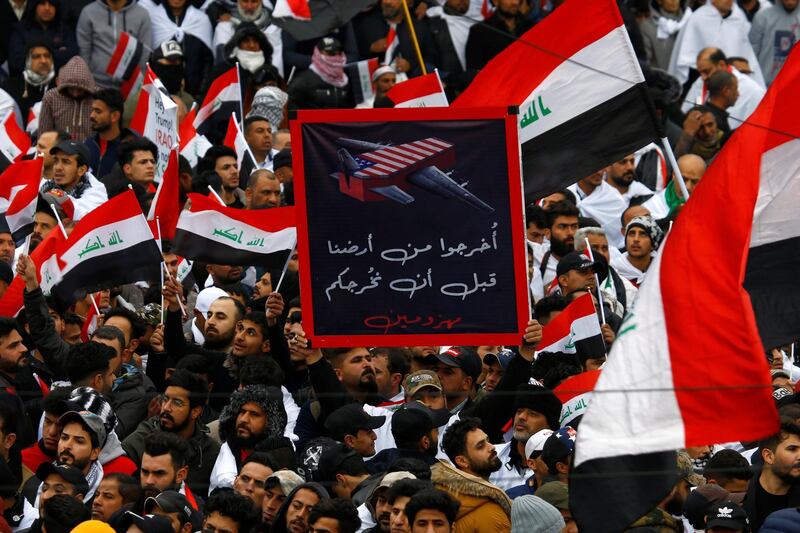 Supporters o fMoqtada Al Sadr hold a sign reading "Get out of our land before you leave defeated" at a protest. Reuters