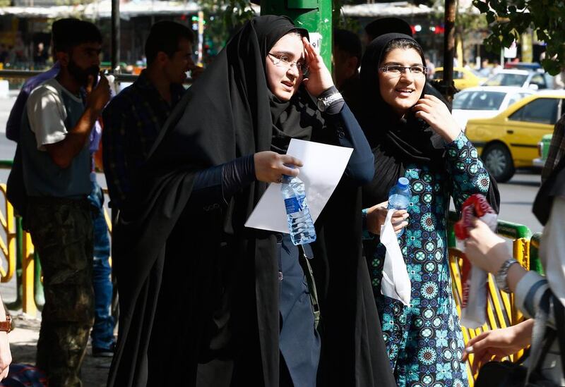 Iranian women carry chilled bottles of water in Tehran. Abedein Taherkenareh / EPA