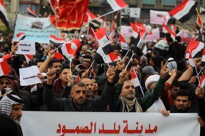 Iraqi demonstrators wave national flags as the take part in an anti-govenment demonstration in the capital Baghdad's Tahrir Square, on December 6, 2019.  Tahrir has become a melting pot of Iraqi society, occupied day and night by thousands of demonstrators angry with the political system in place since the aftermath of the US-led invasion of 2003 and Iran's role in propping it up. / AFP / AHMAD AL-RUBAYE
