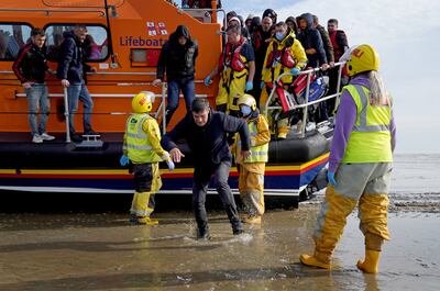 A group of people thought to be migrants are brought in to Dungeness, Kent, on board a lifeboat. PA