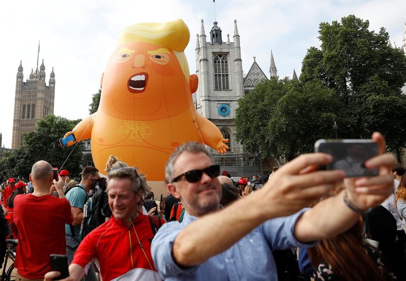 Demonstrators take a photo with the blimp. Reuters