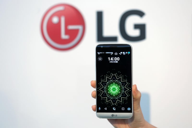 A model poses for photographs with LG Electronics' new smartphone G5 during its launch event in Taipei, Taiwan March 24, 2016. REUTERS/Tyrone Siu/File Photo