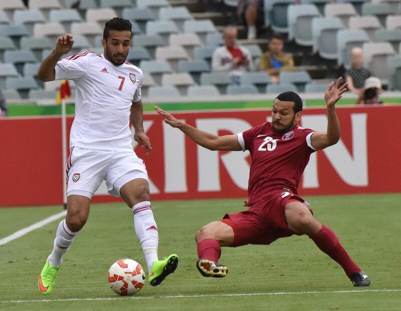 Ali Mabkhout of the UAE avoids a tackle from Ahmed Mohamed of Qatar during the Group C Asian Cup football match between UAE and Qatar in Canberra on January 11, 2015. AFP