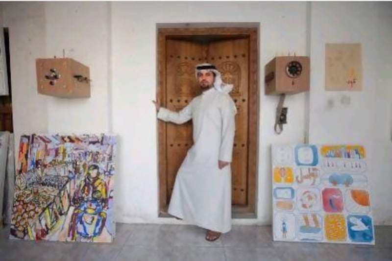 The Emirati artist Nasir Nasrallam at his studio in the Heart of Sharjah with his works, Marketing, left, and Mind Full of Impressions. Jaime Puebla / The National